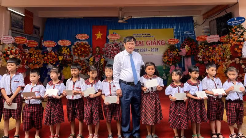 Phó Trưởng Ban Tuyên giáo Trung ương Phan Xuân Thủy trao học bổng cho học sinh nghèo vượt khó tại Trường tiểu học 1 Thị trấn Mỏ Cày. (Ảnh: HOÀNG TRUNG)