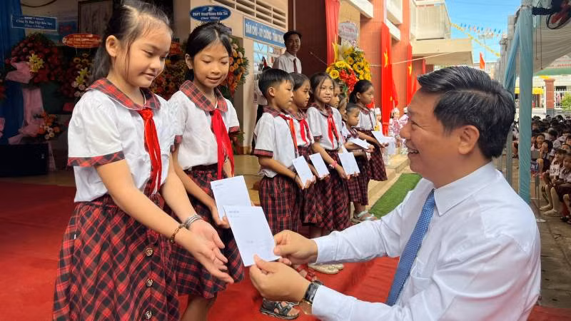 Phó Bí thư Thường trực Tỉnh ủy Bến Tre trao học bổng cho học sinh nghèo vượt khó. (Ảnh: HOÀNG TRUNG)