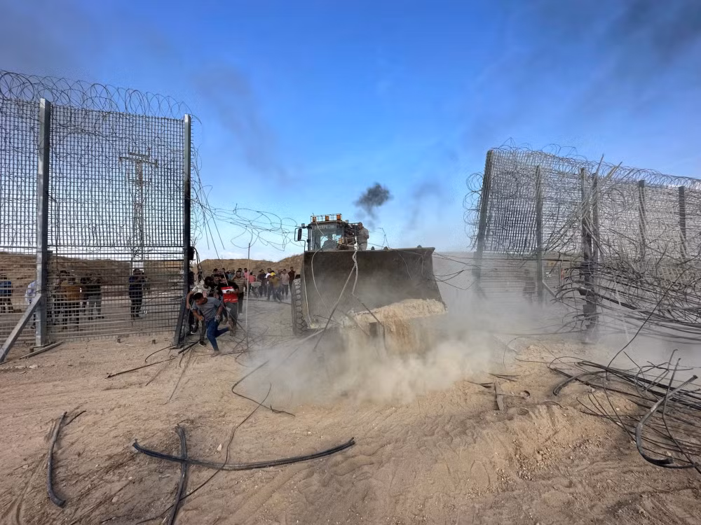 Người Palestine tràn vào phía Israel qua hàng rào ranh giới Israel-Gaza, sau khi các tay súng Hamas xâm nhập vào các khu vực phía nam Israel, ngày 7/10/2023. (Ảnh: Reuters)