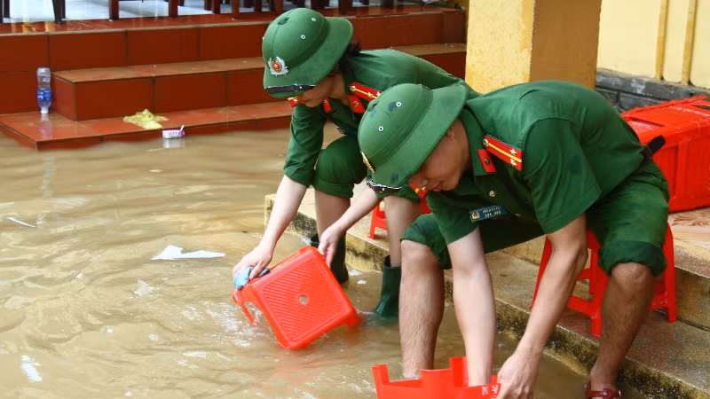 Đoàn viên thanh niên Công an tỉnh Quảng Bình giúp trường học vùng lũ vệ sinh trường lớp, lau rửa bàn ghế.