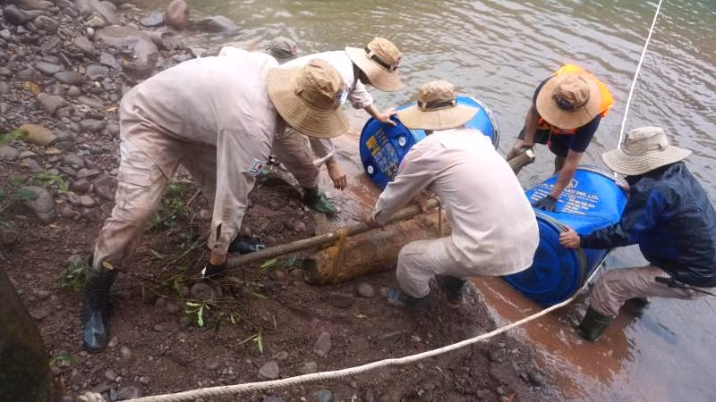Các chuyên gia xử lý buộc quả bom ở Dân Hóa vào bè để di chuyển qua sông đưa về vị trí an toàn để hủy nổ tập trung. Các chuyên gia xử lý buộc quả bom ở Dân Hóa vào bè để di chuyển qua sông đưa về vị trí an toàn để hủy nổ tập trung.