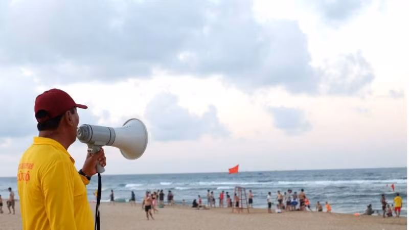 Thành viên đội cứu hộ trên bãi biển Nhật Lệ nhắc nhở du khách tuân thủ quy định để tắm biển an toàn. (Ảnh: minh họa)