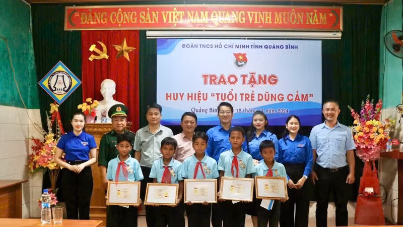 Các đại biểu chụp ảnh lưu niệm cùng với 5 bạn nhỏ mưu trí, dũng cảm.