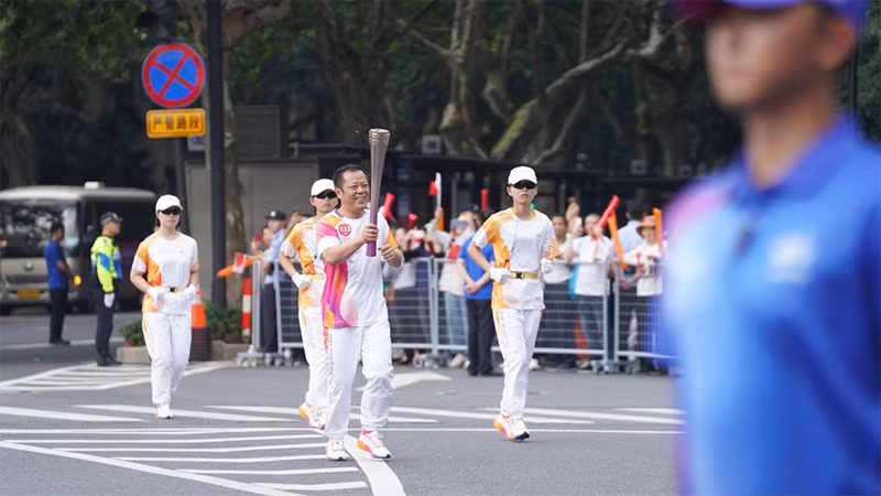 Thành viên rước đuốc ASIAD 19 di chuyển trên đường. (Ảnh: people.com.cn)