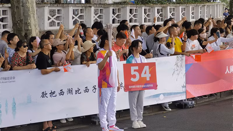 Thành viên rước đuốc thứ 54 chờ tiếp lửa thiêng ASIAD 19. (Ảnh: people.com.cn)