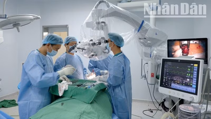 Các bác sĩ thực hiện phẫu thuật thị phạm trên kính vi phẫu. Các bác sĩ thực hiện phẫu thuật thị phạm trên kính vi phẫu.