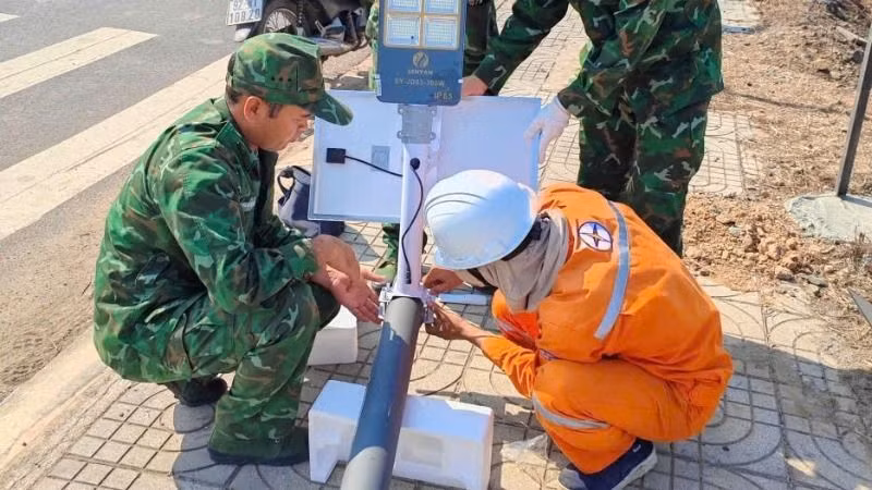 Cán bộ, chiến sĩ Đồn Biên phòng Bo Heng và cán bộ, nhân viên Điện lực thi công công trình.