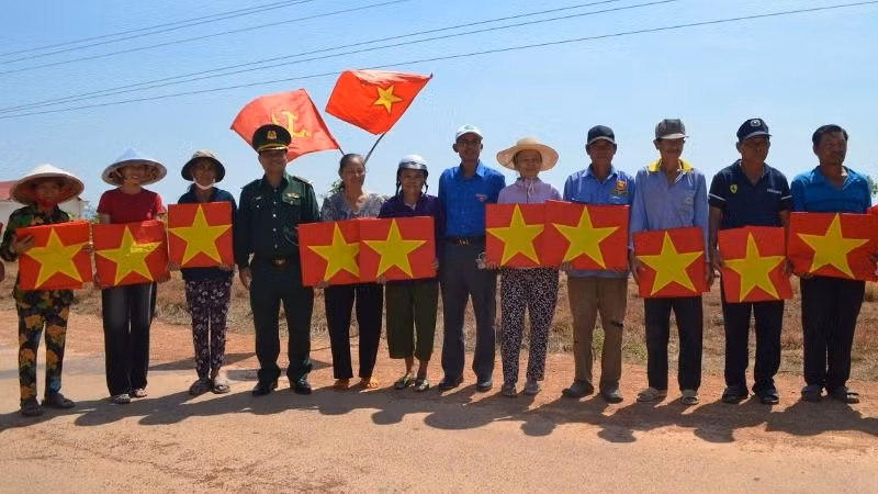 Đại diện lãnh đạo Bộ Chỉ huy Bộ đội Biên phòng tỉnh Đắk Lắk và Tỉnh đoàn Lâm Đồng tặng cờ Tổ quốc cho bà con nhân dân khu vực biên giới.