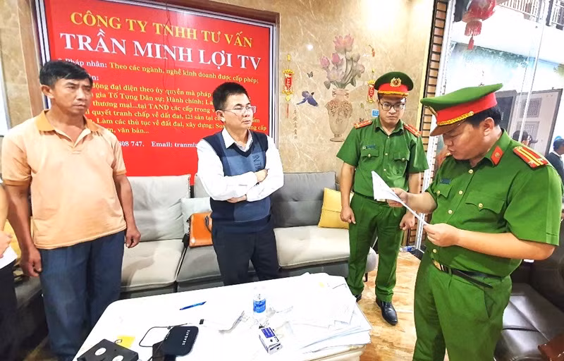 Cơ quan Công an đọc lệnh khởi tố bị can và lệnh bắt tạm giam đối tượng Trần Minh Lợi (người đứng giữa khoanh tay).