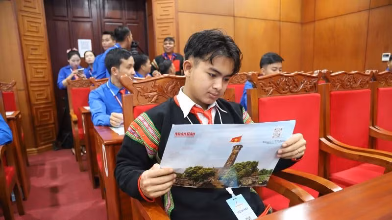 Các thanh niên dự đại hội đọc phụ san đặc biệt của Báo Nhân Dân hằng ngày 10/10/2024 để nắm bắt thông tin về kỷ niệm 70 năm Ngày Giải phóng Thủ đô Hà Nội.