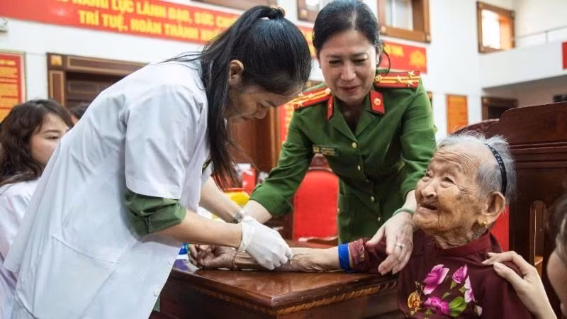 Cán bộ, chiến sĩ Công an và nhân viên Công ty GeneStory tiến hành thu nhận mẫu ADN mẹ liệt sĩ. (Ảnh: Công an tỉnh Đắk Lắk)