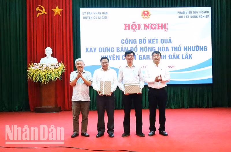 Lãnh đạo Phân viện quy hoạch và thiết kế nông nghiệp thuộc Bộ Nông nghiệp và Phát triển Nông thôn trao bản đồ nông hóa thổ nhưỡng trên địa bàn huyện cho lãnh đạo Ủy ban nhân dân huyện Cư M'gar.