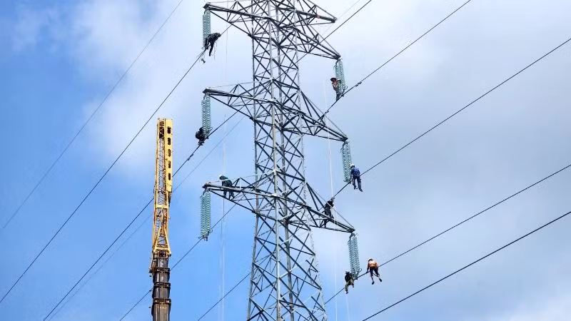Các kỹ sư, công nhân đang tiến hành tháo dỡ trụ điện.