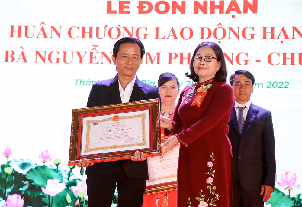 Đại diện Công ty TNHH Lan Anh (bên trái) nhận Huân chương Lao động hạng ba.