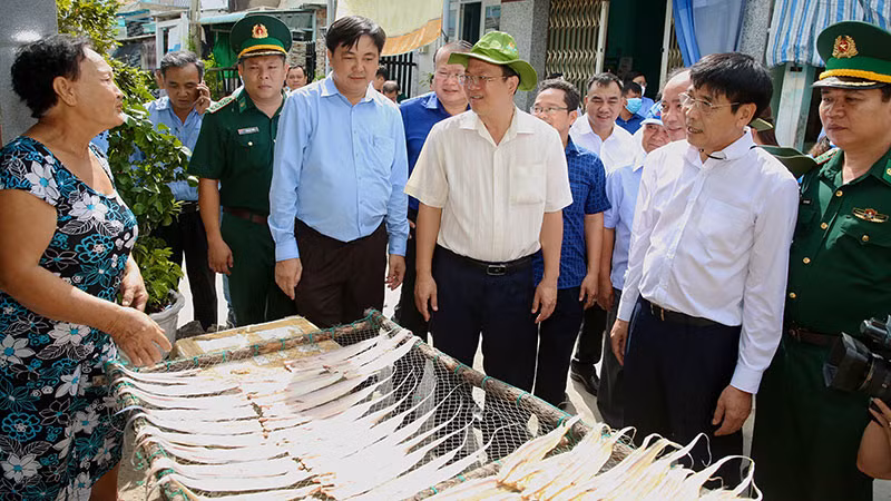 Phó Bí thư Thành ủy Thành phố Hồ Chí Minh Nguyễn Hồ Hải (áo trắng đội mũ) trò chuyện cùng người dân trên xã đảo Thạnh An, huyện Cần Giờ. (Ảnh: HOÀNG TRIỀU)