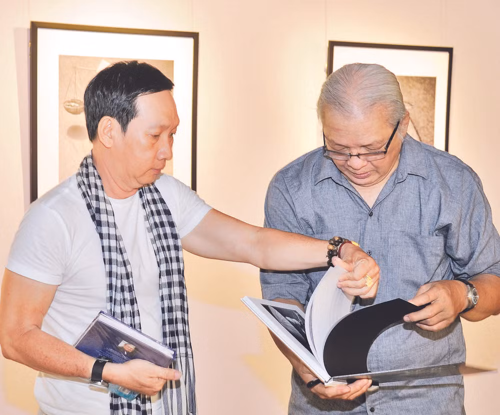 Nghệ sĩ nhiếp ảnh Trần Thế Phong (người bên trái) tại triển lãm Bóng” tổ chức ở Hội Mỹ thuật Thành phố Hồ Chí Minh. (Ảnh: Nhân vật cung cấp)