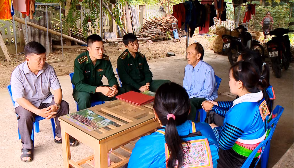 Ông Lâu Minh Pó (ngoài cùng bên trái) cùng Bộ đội Biên phòng vận động người dân xóa bỏ hủ tục, xây dựng nếp sống mới. (Ảnh Trang Nhung)