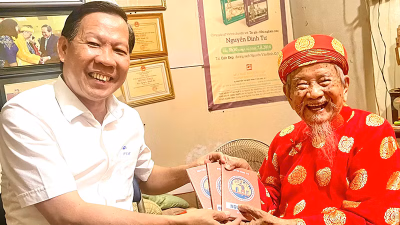 Nhà nghiên cứu Nguyễn Đình Tư tặng Chủ tịch Ủy ban nhân dân Thành phố Hồ Chí Minh Phan Văn Mãi bộ sách thiếu nhi vừa mới phát hành của ông.