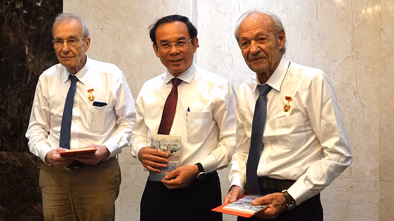 Đồng chí Nguyễn Văn Nên, Ủy viên Bộ Chính trị, Bí thư Thành ủy Thành phố Hồ Chí Minh trao tặng cho ông Olivier Parriaux và ông Bernard Bachelard Huy hiệu Thành phố Hồ Chí Minh.