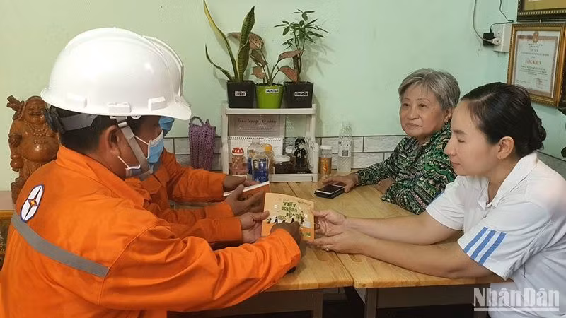 Công nhân ngành điện Thành phố Hồ Chí Minh hướng dẫn người dân cách sử dụng điện hiệu quả.
