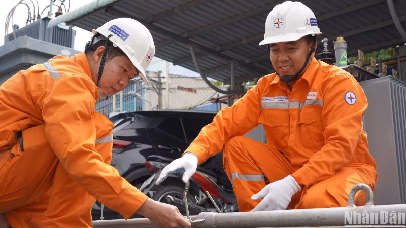 Anh Huỳnh Thanh Thuận (bìa phải) đang hướng dẫn sử dụng sáng kiến “Sào đỡ cáp ngầm”.