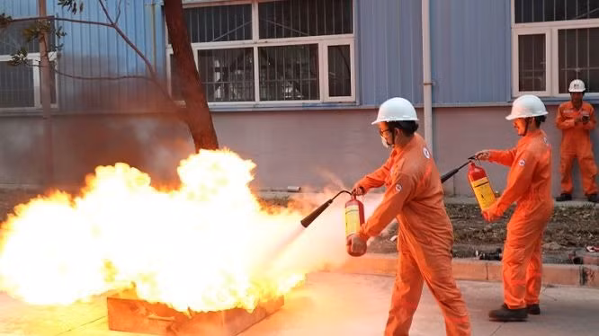 Cán bộ, công nhân viên và người lao động sử dụng bình chữa cháy di động dập tắt đám cháy giả định.