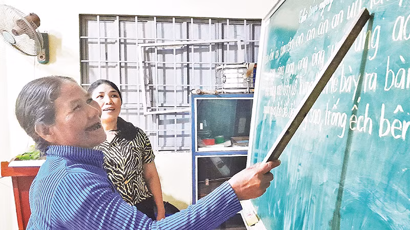 Học sinh lớn tuổi tại lớp học xóa mù chữ tại thôn 6 (xã Long Tân) đang tập đọc.