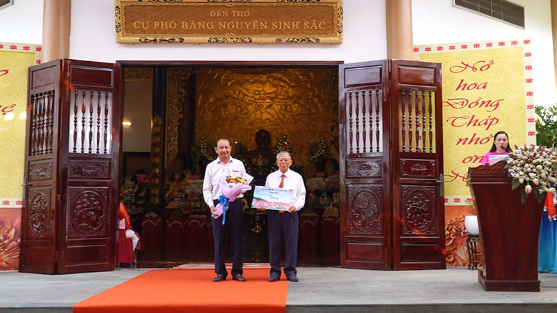 Doanh nghiệp trao bảng tượng trưng ủng hộ Quỹ Khuyến học Nguyễn Sinh Sắc. (Ảnh: HỮU NGHĨA)