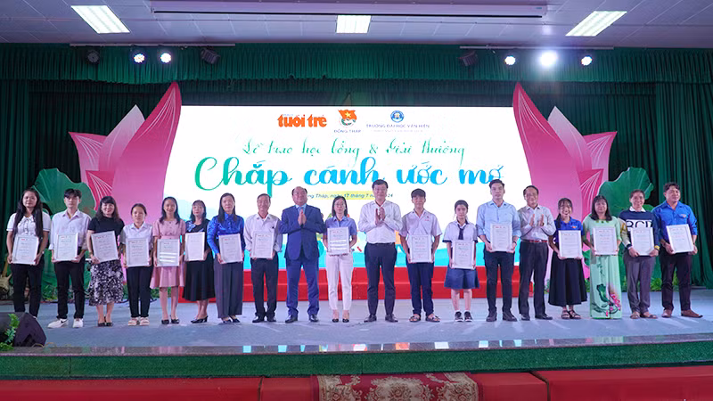 Đồng chí Lê Quốc Phong và thầy Nguyễn Minh Đức, Hiệu trưởng Trường đại học Văn Hiến trao giải cho các tác giả có bài viết hay gửi về học bổng "Chắp cánh ước mơ". (Ảnh: HỮU NGHĨA)