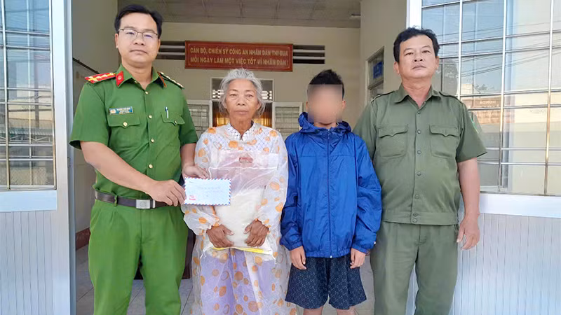 Công an xã An Bình hỗ trợ cháu bé đi lạc. (Ảnh: Công an cung cấp)
