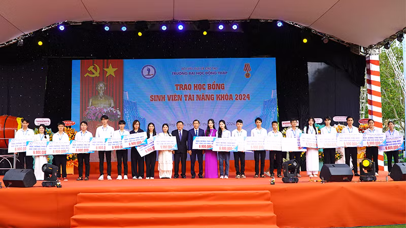 Lãnh đạo Trường đại học Đồng Tháp trao học bổng khuyến học cho các sinh viên. (Ảnh: HỮU NGHĨA)