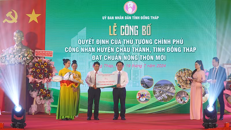 Bộ trưởng Lê Minh Hoan thay mặt Đoàn đại biểu Quốc hội đơn vị tỉnh Đồng Tháp, đơn vị bầu cử số 3, trao bảng tượng trưng tặng 5 căn nhà Đại đoàn kết. (Ảnh: HỮU NGHĨA)
