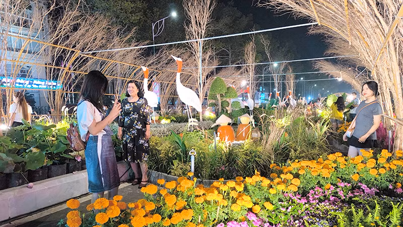 Du khách tham quan, chụp ảnh tại một đại cảnh của đường hoa. Ảnh: HỮU NGHĨA