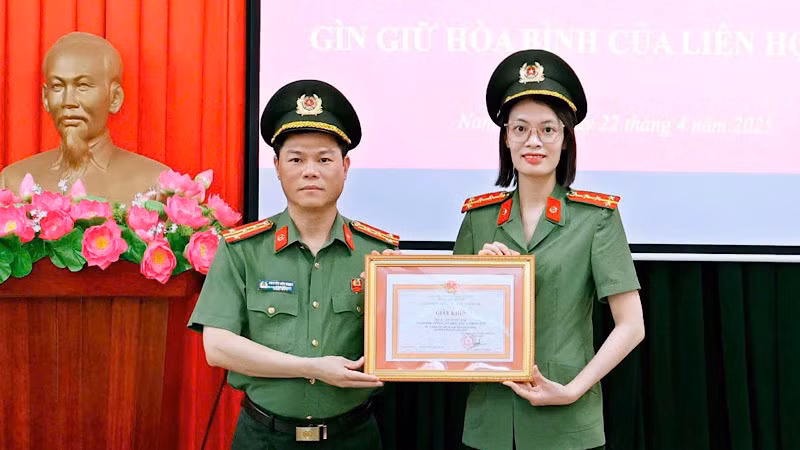 Đại tá Nguyễn Hữu Mạnh, Giám đốc Công an tỉnh Nam Định trao Giấy khen cho Đại úy Trần Mỹ Linh. (Ảnh: BÍCH MẬN)