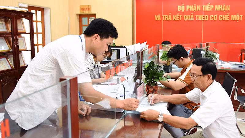 Cán bộ xã Giao Phong, huyện Giao Thủy (Nam Định) hướng dẫn người dân đến làm thủ tục hành chính tại Bộ phận tiếp nhận và trả kết quả theo cơ chế một cửa.