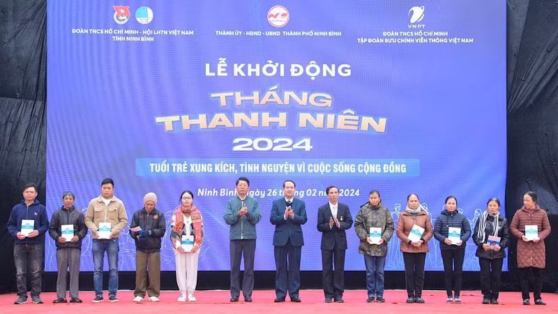 Các đại biểu trao tặng thẻ bảo hiểm y tế cho người có hoàn cảnh khó khăn. Ảnh: NGỌC HÀ