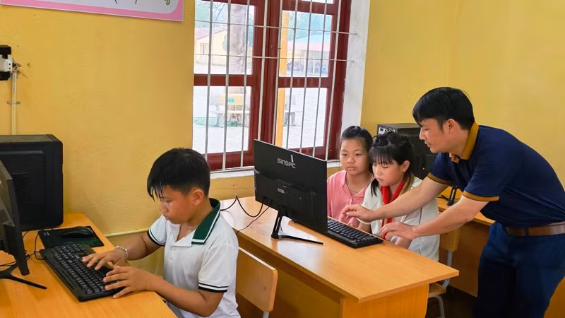 Thầy giáo hướng dẫn học sinh học tin học. Thầy giáo hướng dẫn học sinh học tin học.