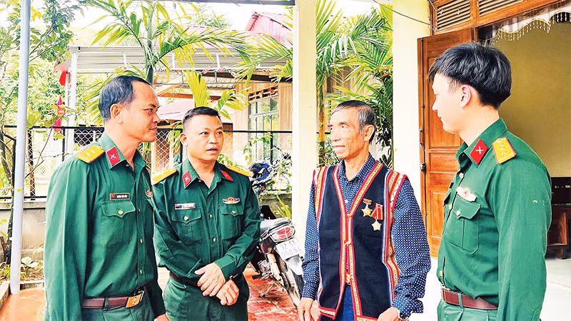 Cán bộ, chiến sĩ Ðoàn Kinh tế-Quốc phòng 207 thăm hỏi người có uy tín vùng biên giới huyện Nam Giang, tỉnh Quảng Nam. 