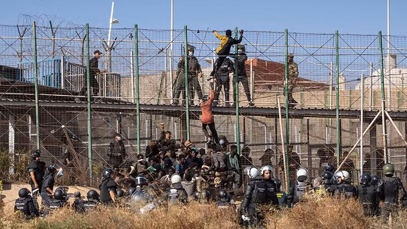 Người di cư cố gắng vượt biên giới từ Maroc vào vùng Melilla của Tây Ban Nha. (Ảnh AP) 
