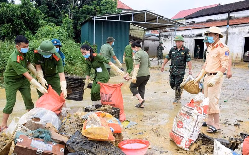 Lực lượng công an, quân đội, dân quân tự vệ giúp người dân xã Thanh Mỹ, huyện Thanh Chương vệ sinh môi trường sau mưa, lũ. (Ảnh XUÂN HOÀNG)