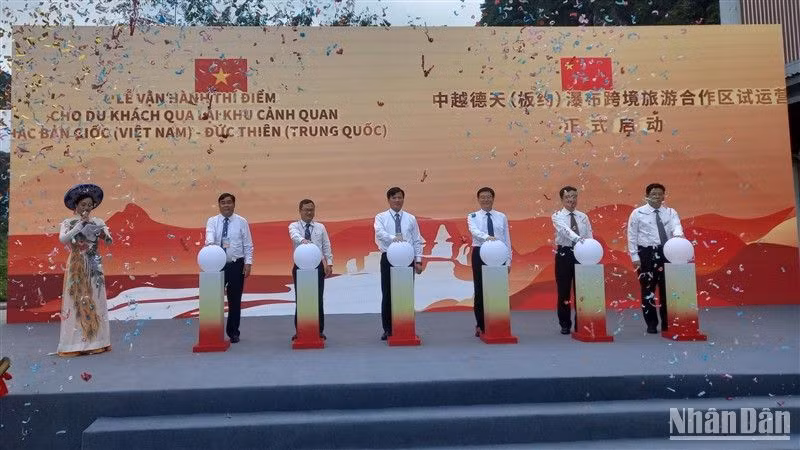 Các đại biểu thực hiện nghi thức vận hành thí điểm cho du khách qua lại tham quan thác Bản Giốc-Đức Thiên.