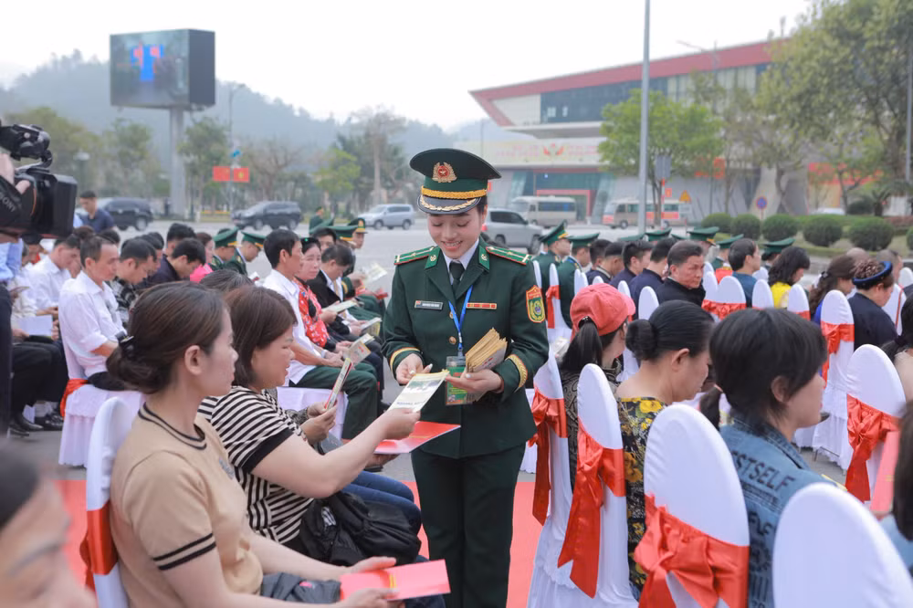 Nữ sĩ quan trẻ Bộ đội Biên phòng Lạng Sơn phát tờ rơi tuyên truyền pháp luật cho bà con nhân dân biên giới.
