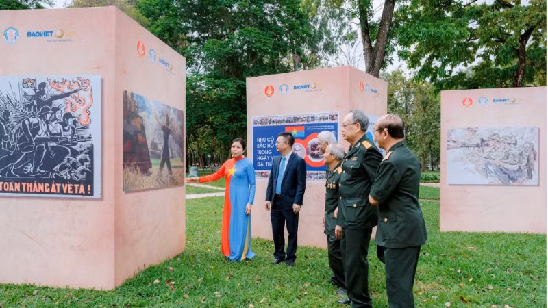 Họa sĩ Nguyễn Thu Thủy giới thiệu tác phẩm tới các cựu chiến binh tham quan triển lãm. (Ảnh: AN HẢI)
