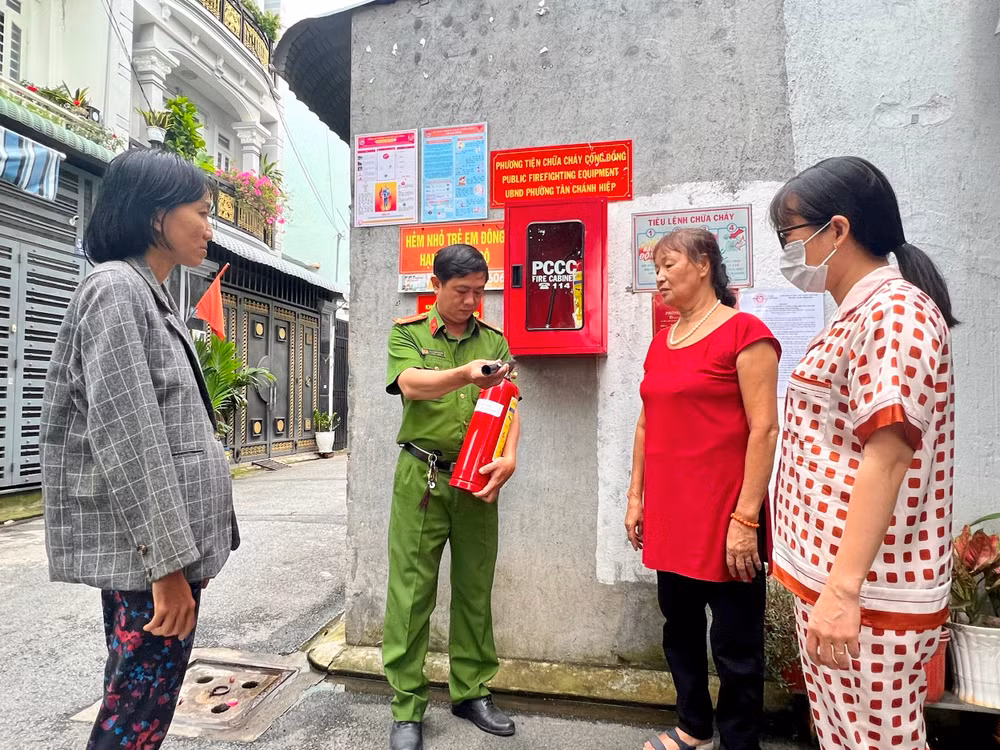 Công an phường Tân Chánh Hiệp (Quận 12, Thành phố Hồ Chí Minh) hướng dẫn người dân sử dụng bình chữa cháy để bảo đảm Tổ liên gia phòng cháy, chữa cháy hoạt động hiệu quả.