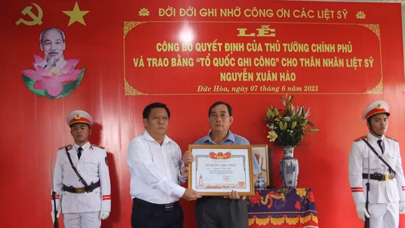 Lãnh đạo tỉnh Long An trao Quyết định của Thủ tướng Chính phủ và trao bằng "Tổ quốc ghi công" cho thân nhân Liệt sĩ Nguyễn Xuân Hào.