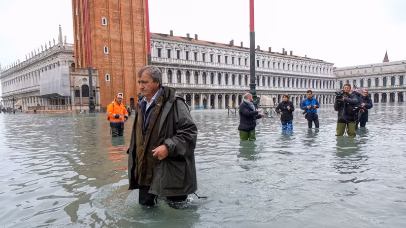 Thị trưởng Venice Luigi Brugnaro lội qua Quảng trường St. Mark khi mực nước dâng cao bất thường hồi năm 2019. (Ảnh: REUTERS)