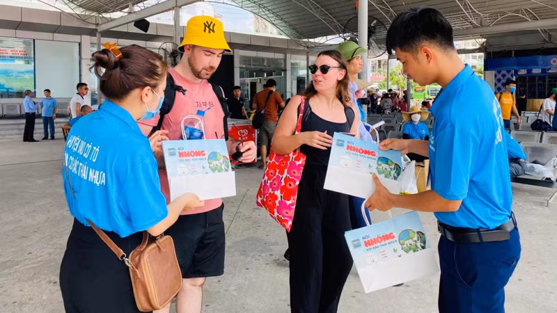Đoàn công tác huyện Cô Tô tuyên truyền và cung cấp túi giấy thay thế túi nilon cho du khách trong giai đoạn đầu thí điểm. (Ảnh: Trung tâm Thông tin-Văn hóa huyện Cô Tô) 