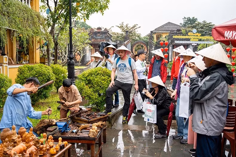 Khách quốc tế tham quan, tìm hiểu quy trình sản xuất các mặt hàng thủ công mỹ nghệ tại thành phố Hội An hôm 1/1. (Ảnh: TẤN NGUYÊN) 