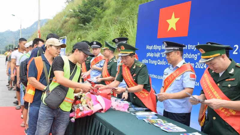 Cán bộ, chiến sĩ Đồn Biên phòng Tân Thanh, huyện Văn Lãng, Lạng Sơn (Việt Nam) và lực lượng chức năng Trạm Kiểm tra Biên phòng Pò Chài, Quảng Tây (Trung Quốc), phối hợp phát tờ rơi tuyên truyền pháp luật cho người dân qua lại biên giới. 