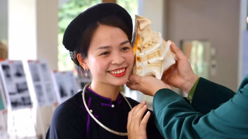 Nụ cười rạng rỡ của đồng bào dân tộc Tày khi tương tác với vỏ ốc biển từ Trường Sa.